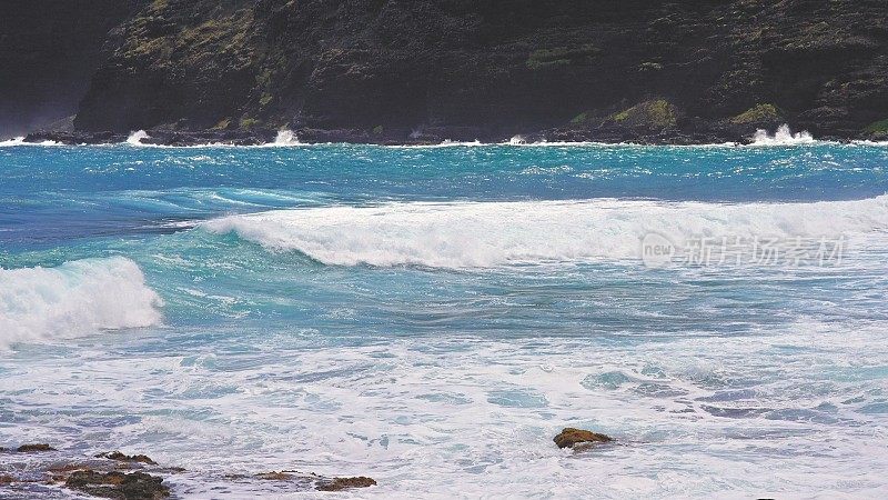 太平洋的蓝色海浪打败了瓦胡岛火山悬崖。蓝绿色的水的颜色。晴朗的一天。夏威夷群岛。DCI 4 k。缓慢的运动。